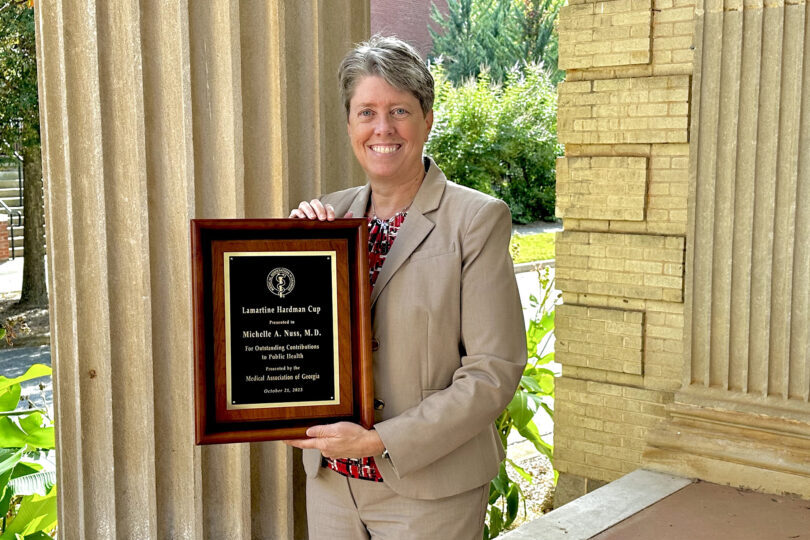 Dean Shelley Nuss holds up her new award.